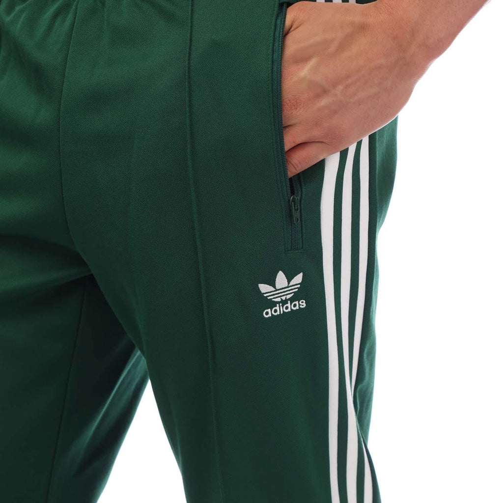 Green adidas track pants with full-zip pocket and white triple side stripes