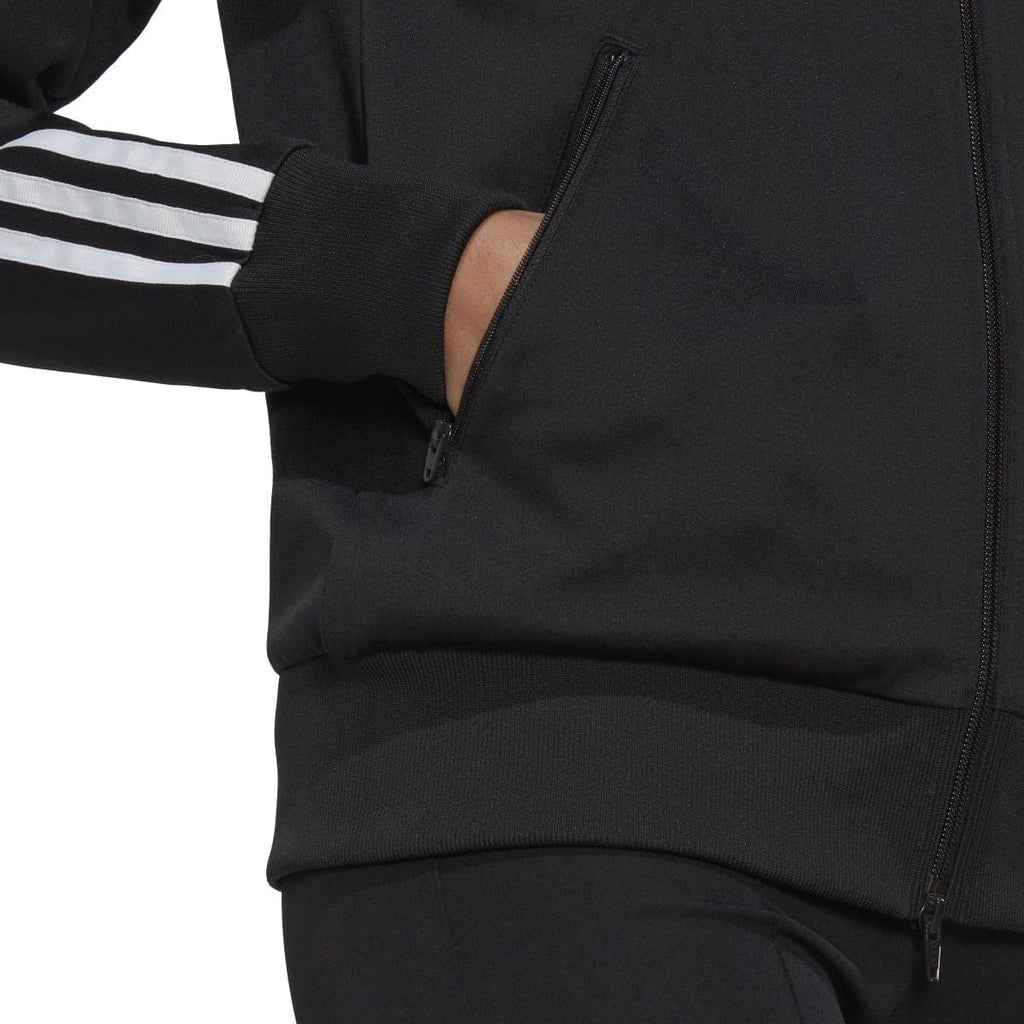 Black track top close-up of ribbed hem, sleeve stripes, and zip seam detail
