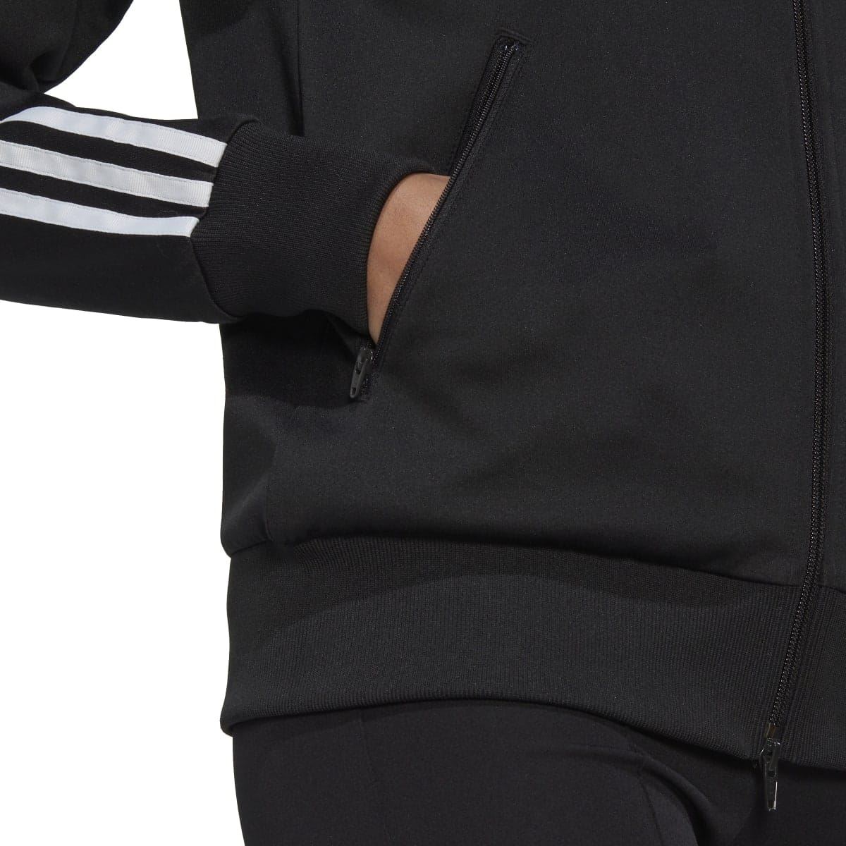 Black track top close-up of ribbed hem, sleeve stripes, and zip seam detail