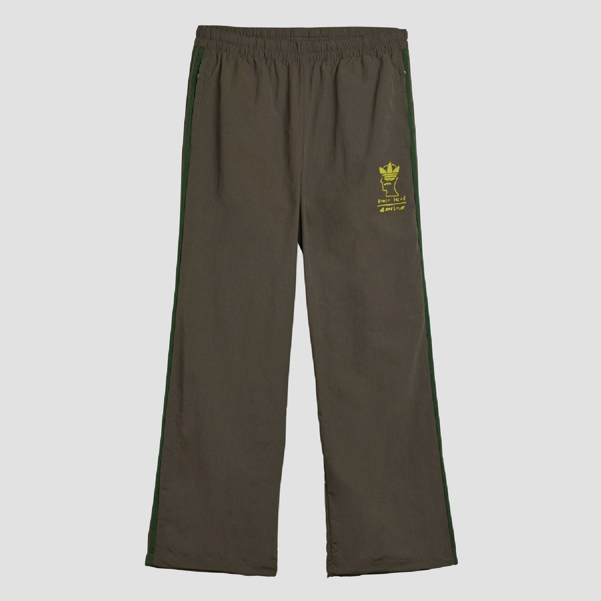 Chocolate track pants with elastic waist, green side stripes, yellow logo patch