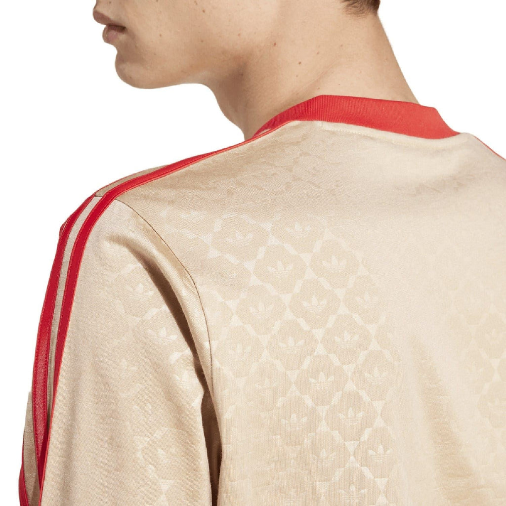 Close-up of beige adidas Originals jersey shoulder and sleeve with red stripe trim
