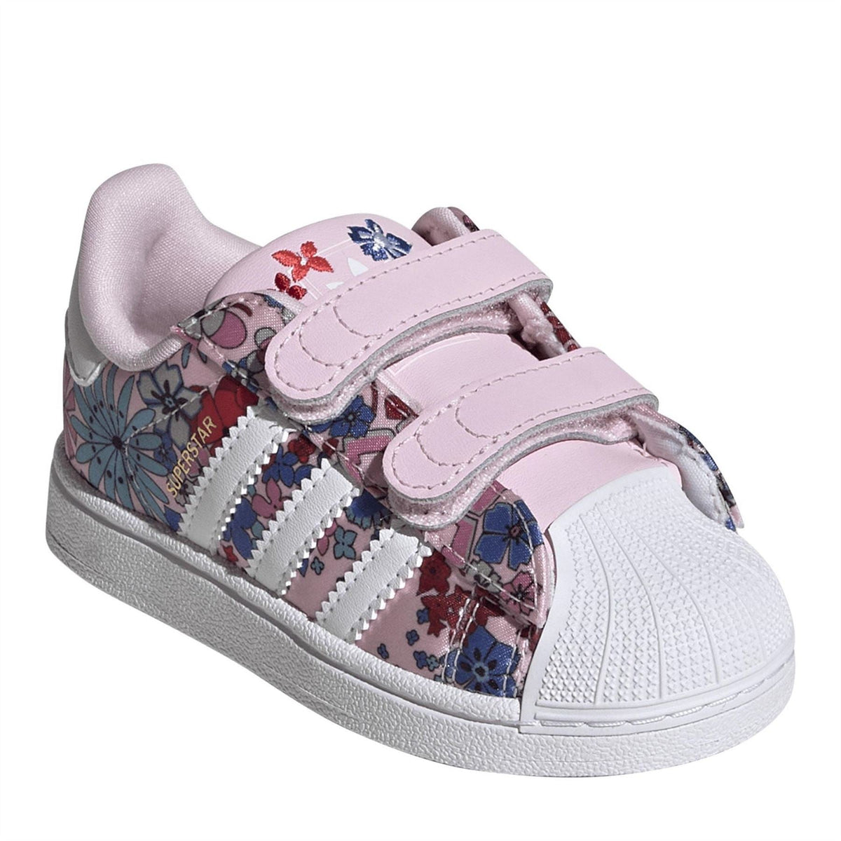 Pink and white low-top sneakers with Velcro straps, floral panels, and three side stripes