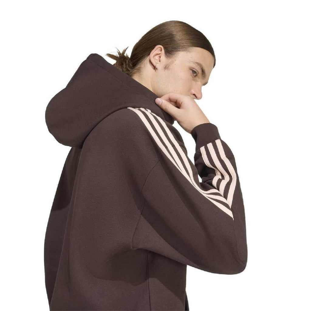 Dark brown hoodie showing close-up side panel with white 3-stripe sleeve and pocket