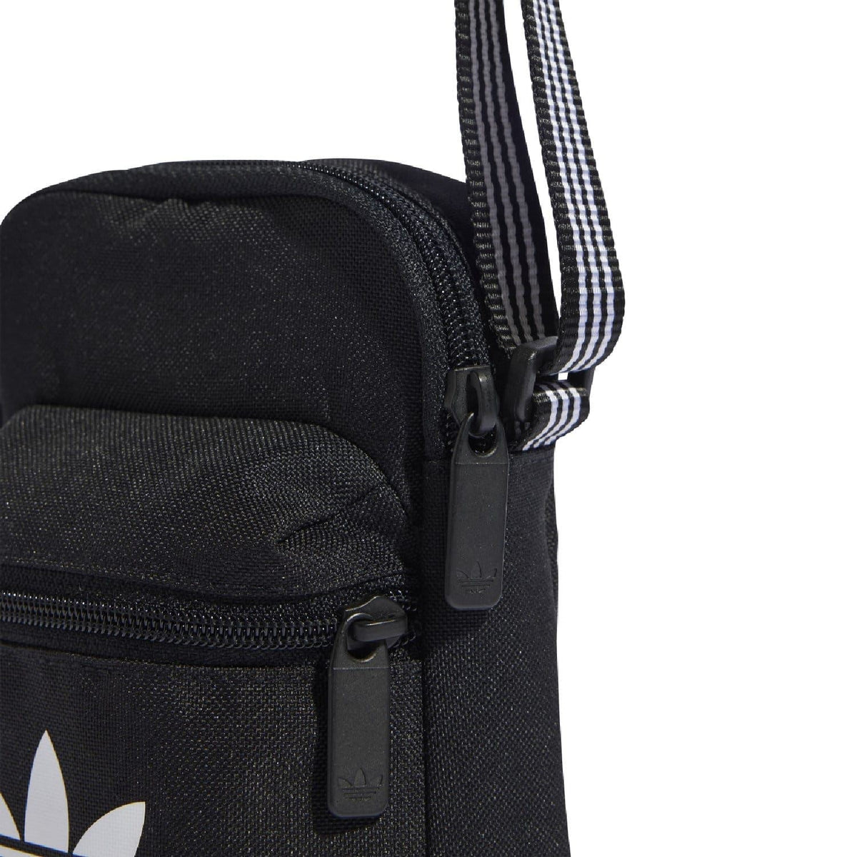 Black adidas Originals festival bag close-up of front zipper, striped strap