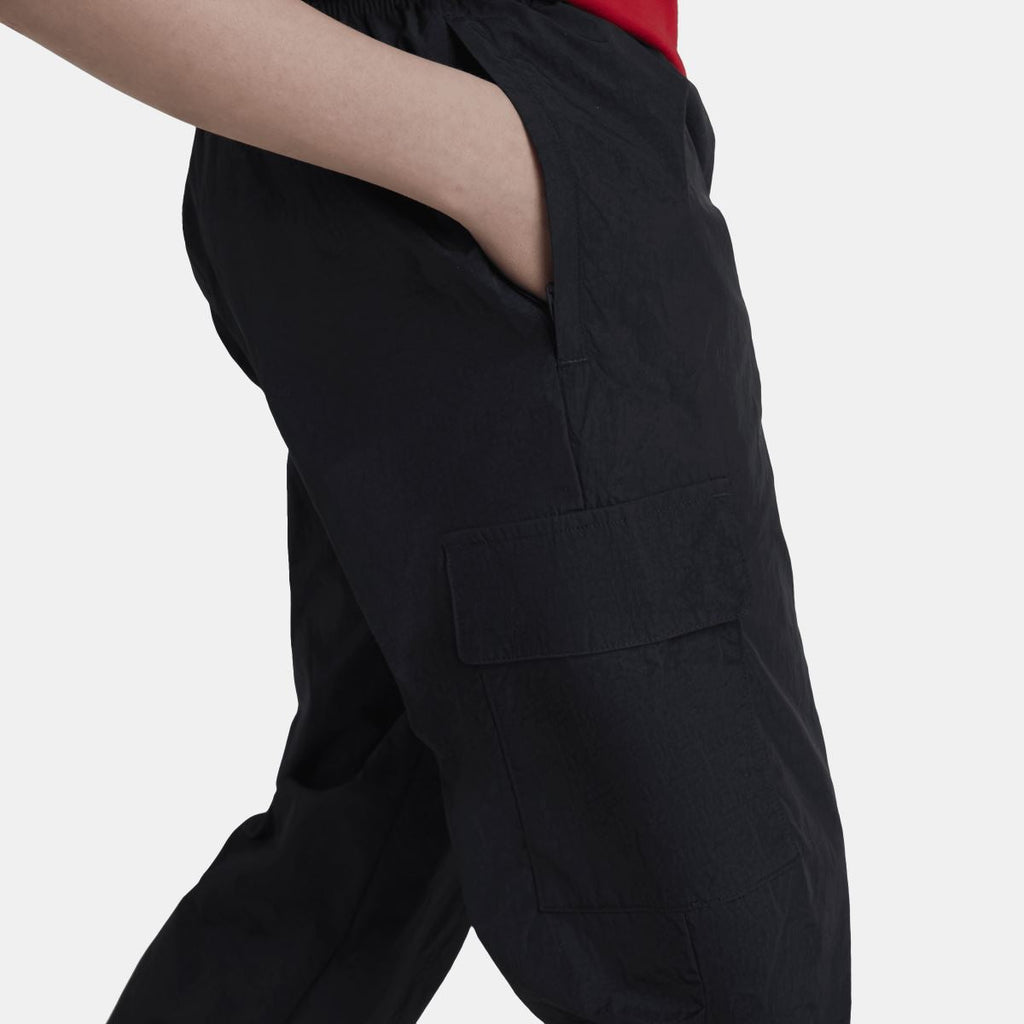 Black cargo track pants close-up showing side pocket and stitched front seam