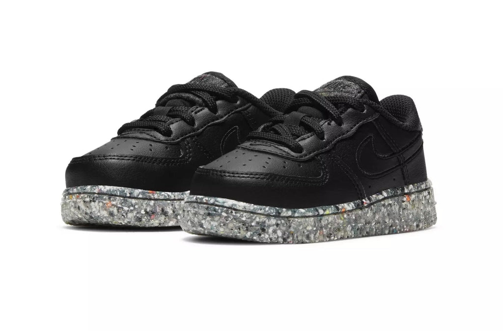 Toddler black low-top sneakers showing laces and speckled platform sole