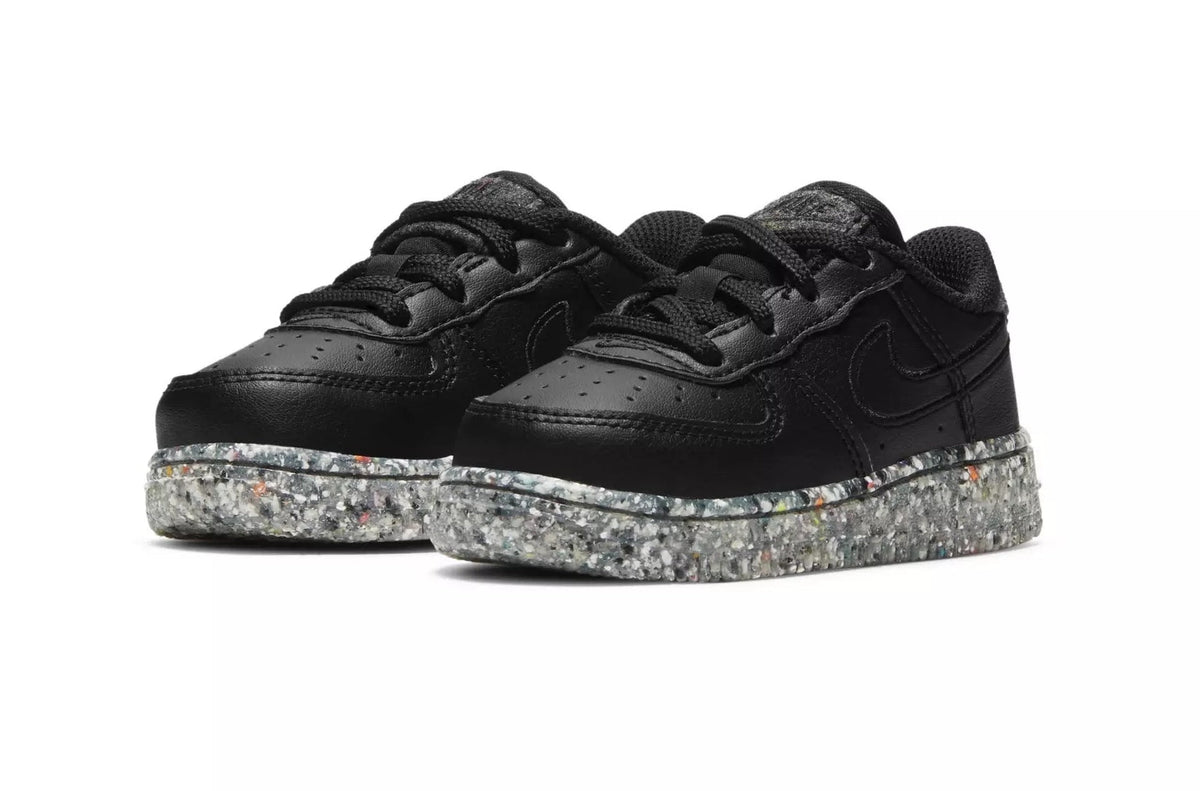 Toddler black low-top sneakers showing laces and speckled platform sole