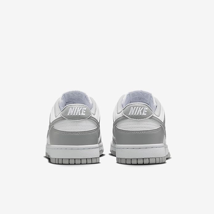 Rear view of white and light gray Nike Dunk Low sneakers with Nike heel tab.