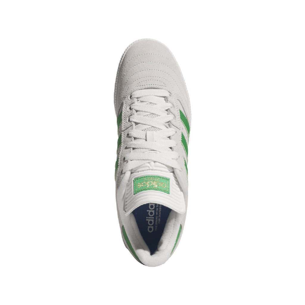 White leather-look sneaker with green stripes and lace-up opening.
