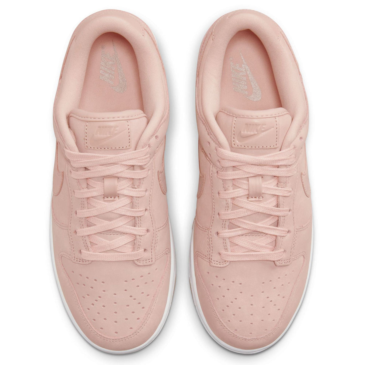 Pink Nike lace-up sneaker tongues and laces, top view of both shoes