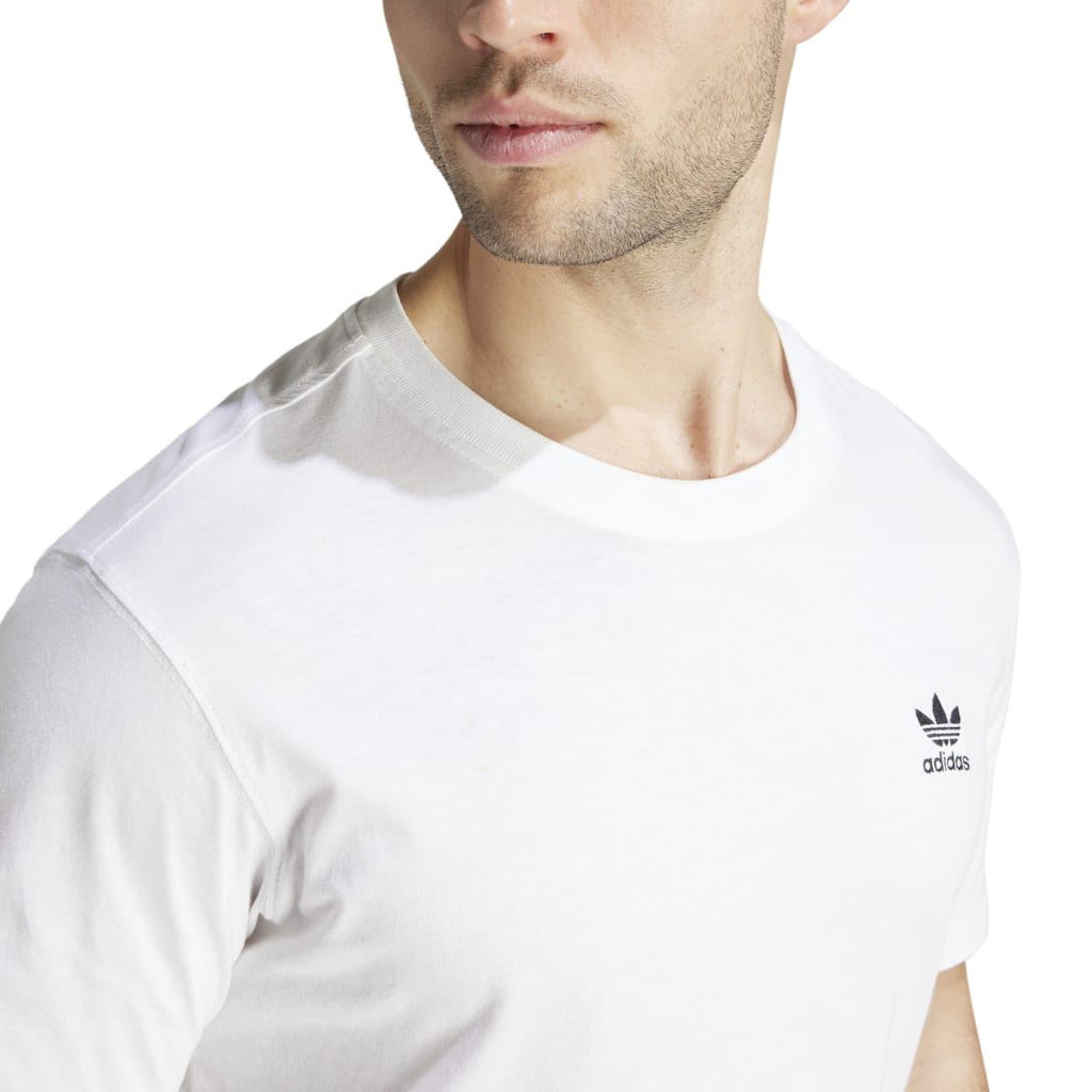 Close-up: white crew-neck T-shirt with adidas trefoil logo on left chest