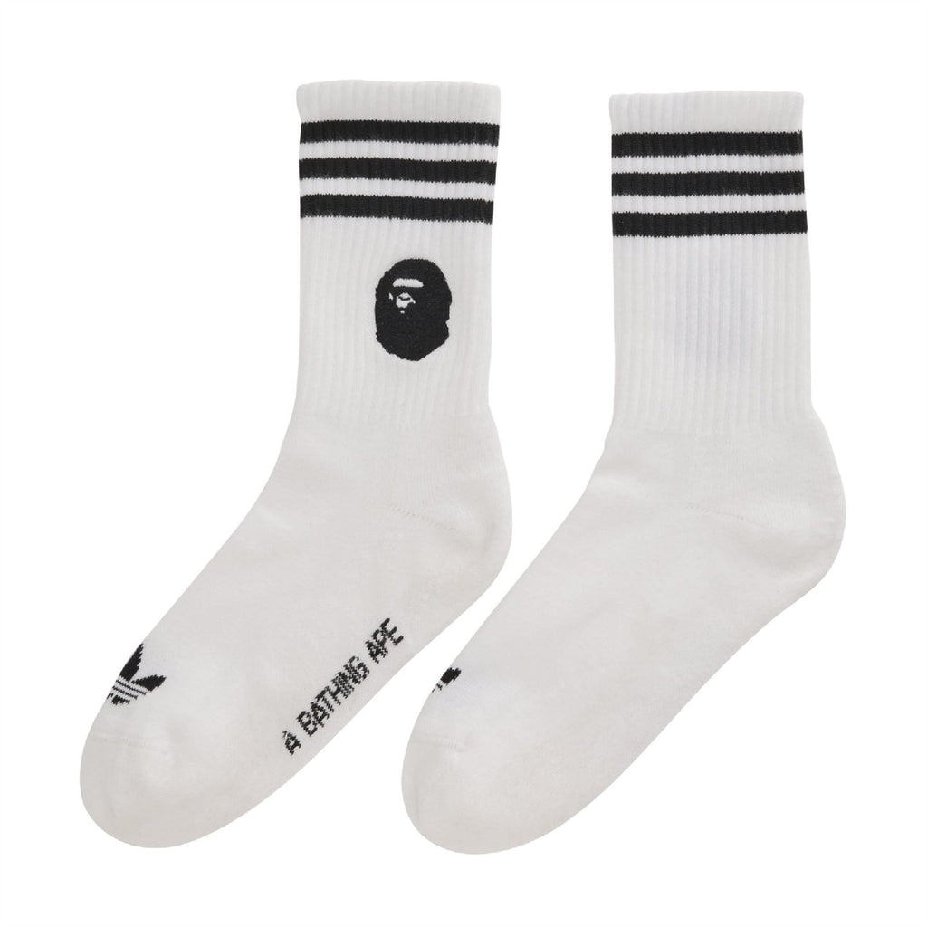 White crew socks with black top stripes and black Bape head logo