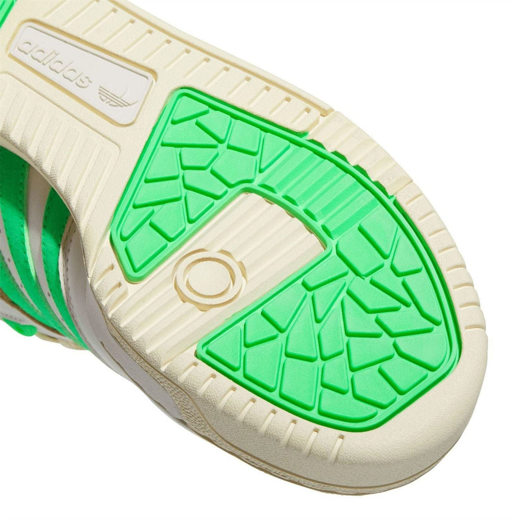 Rubber outsole with raised tread, off-white base and bright green traction insert