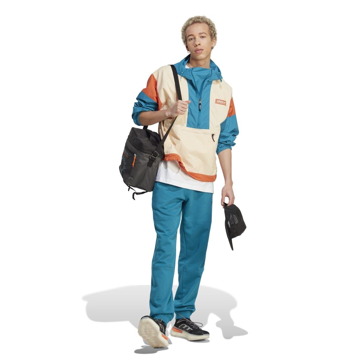 adidas Originals windbreaker jacket worn with teal track pants and sneakers