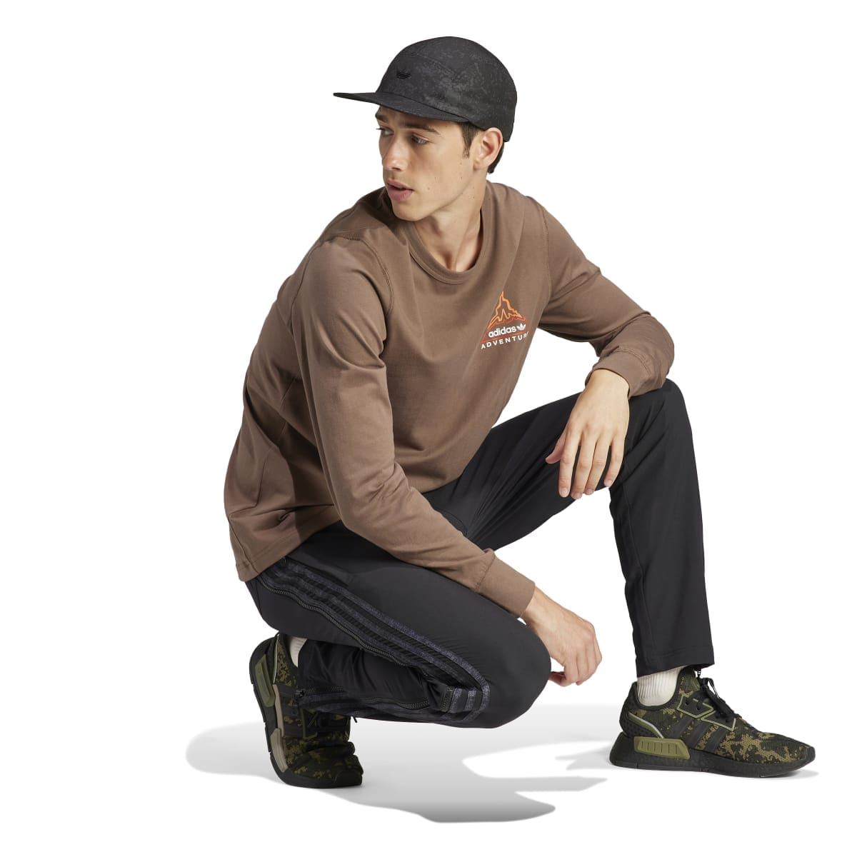adidas Originals brown long-sleeve T-shirt worn with cap; crew neck and adventure logo