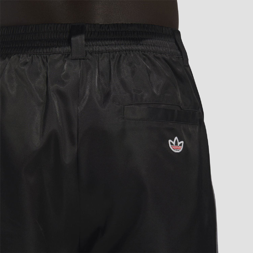 adidas Originals black tracksuit bottoms close-up: elastic waistband and front pocket