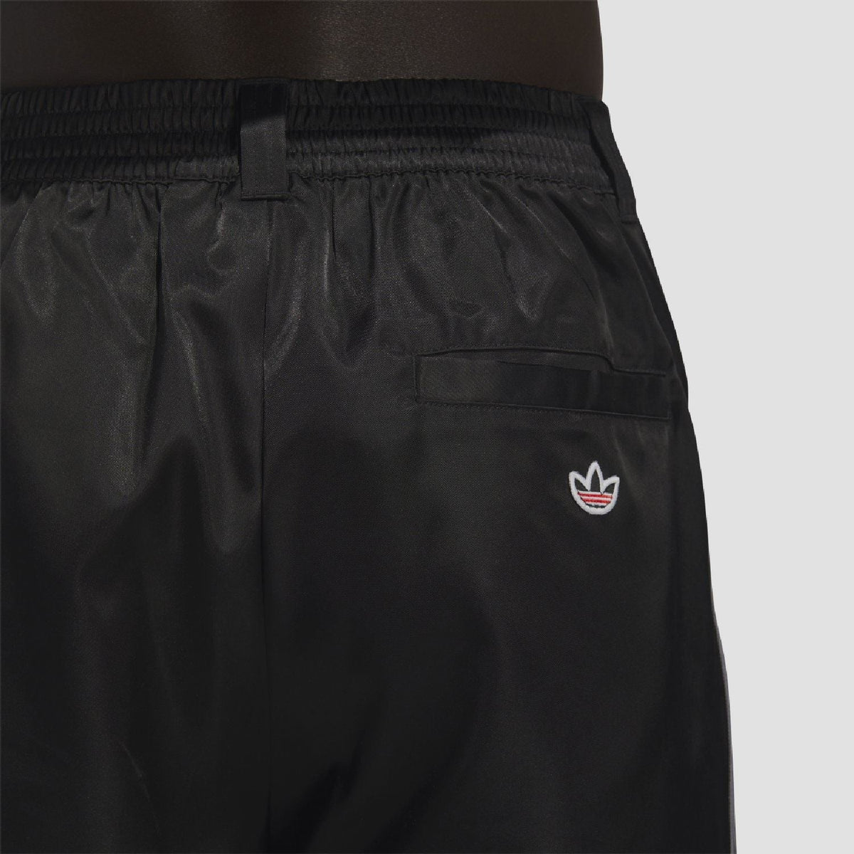 adidas Originals black tracksuit bottoms close-up: elastic waistband and front pocket