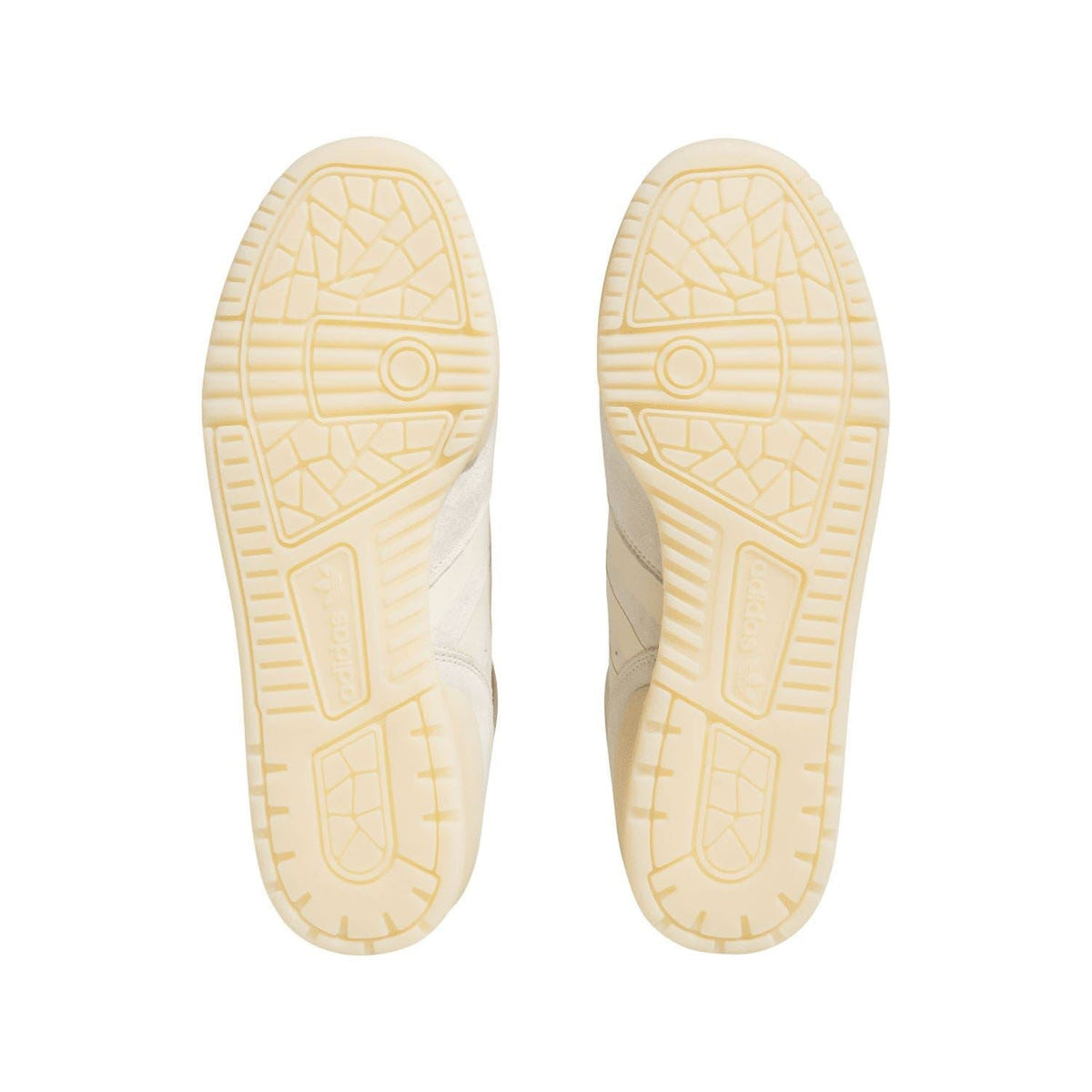 Pair of off-white sneaker outsoles with textured traction pattern in cream