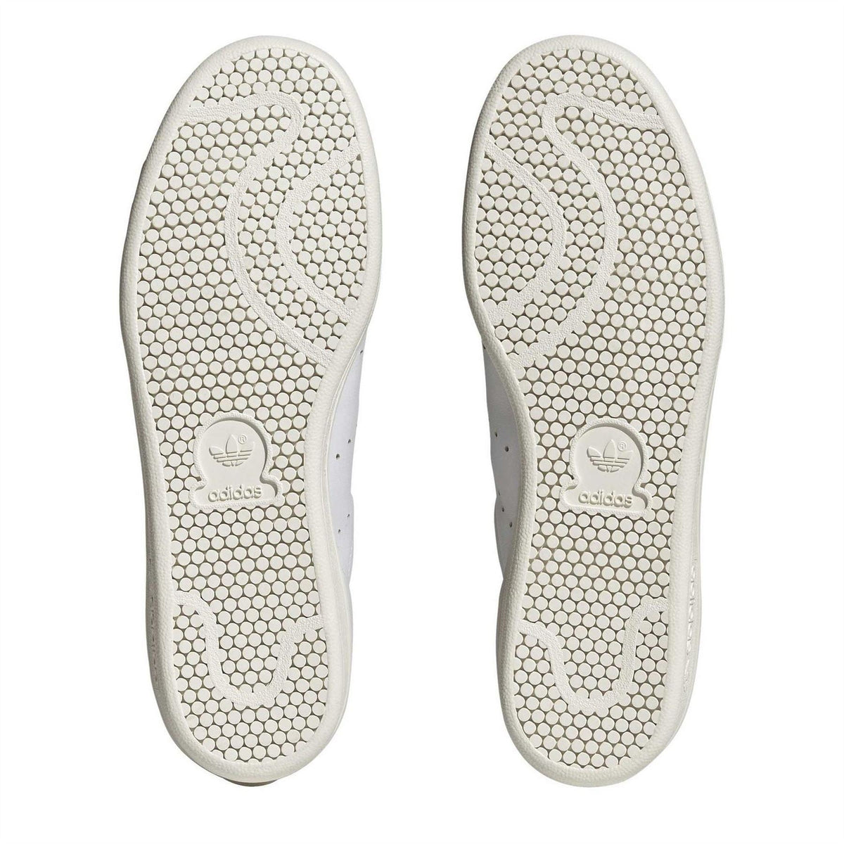 Pair of white rubber outsoles with textured tread and adidas trefoil logo