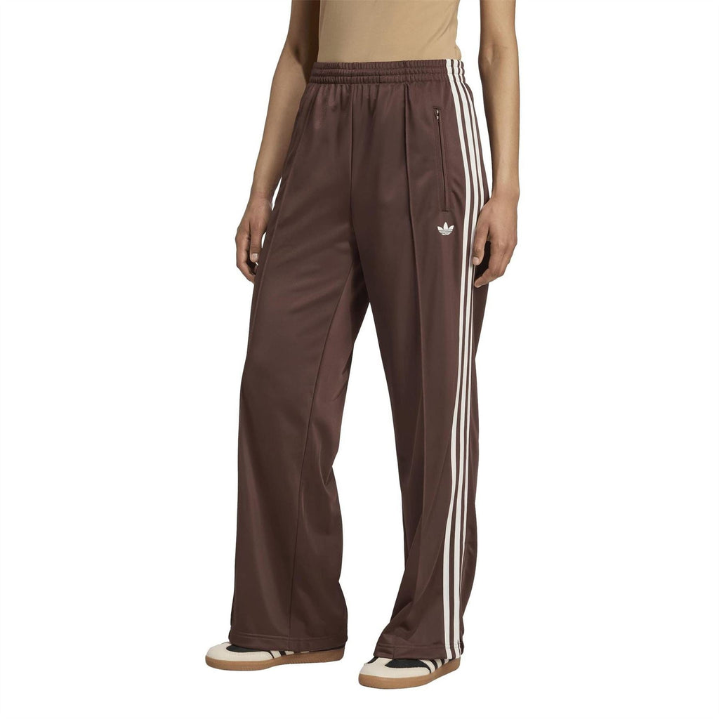Brown track pants with white triple side stripes, elastic waist, and zip pocket
