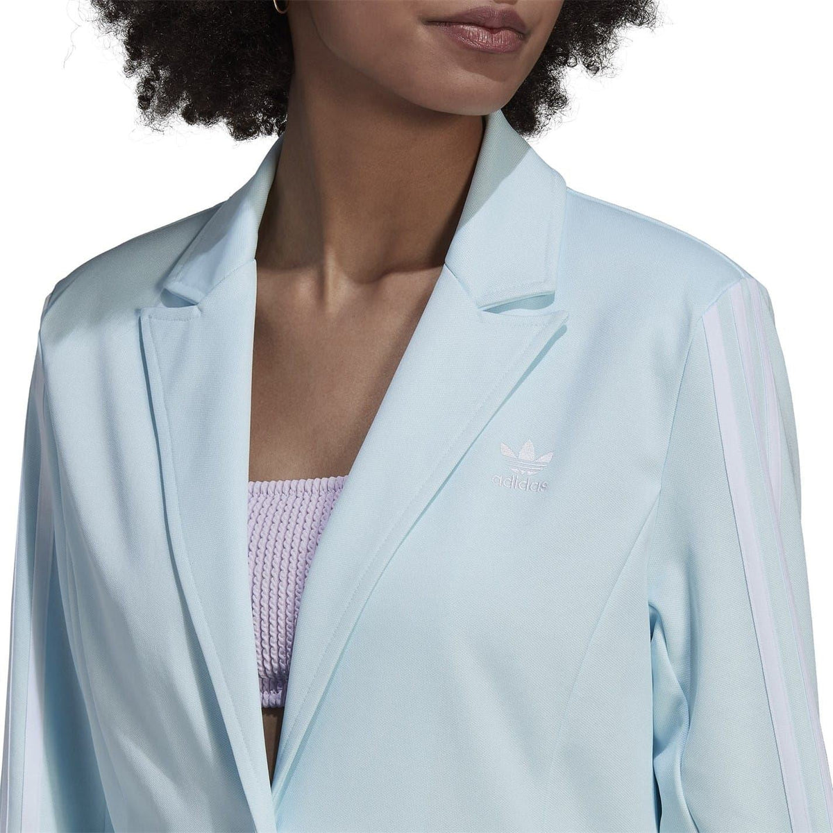 Light blue blazer jacket close-up with notch collar, flap pockets, and small logo