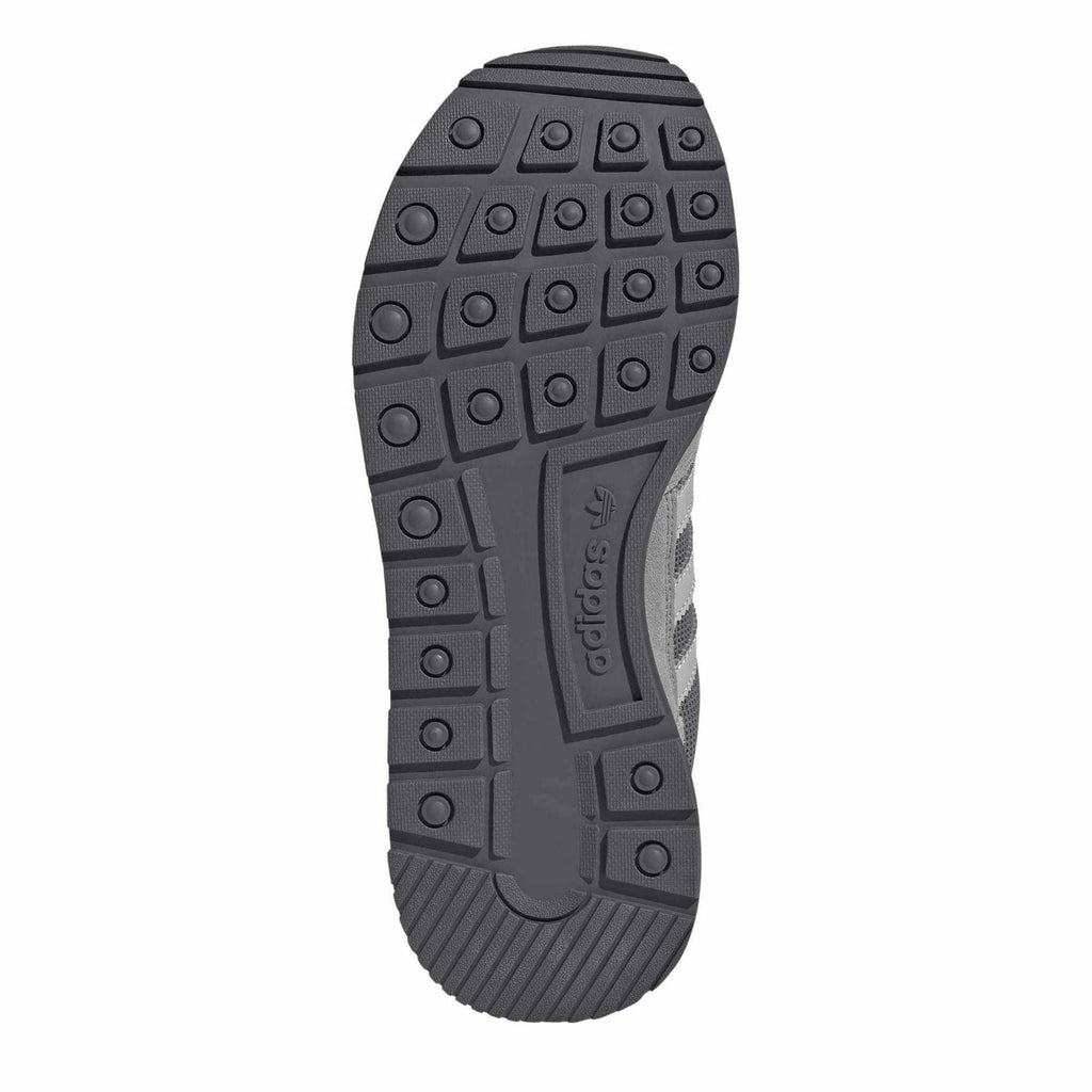 Grey outsole tread with circular traction nubs under sneaker