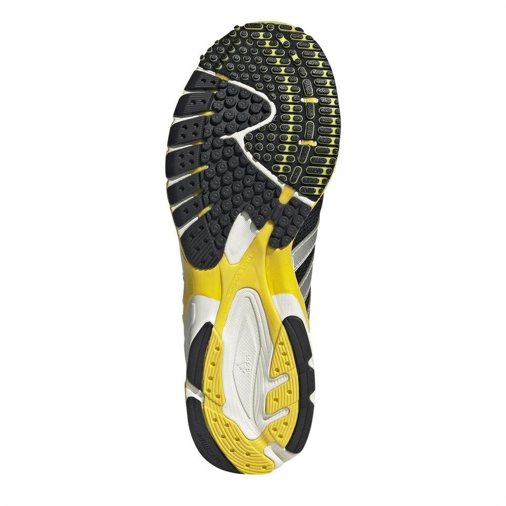 Low-top sneaker outsole with dark tread pods and yellow sidewall detail