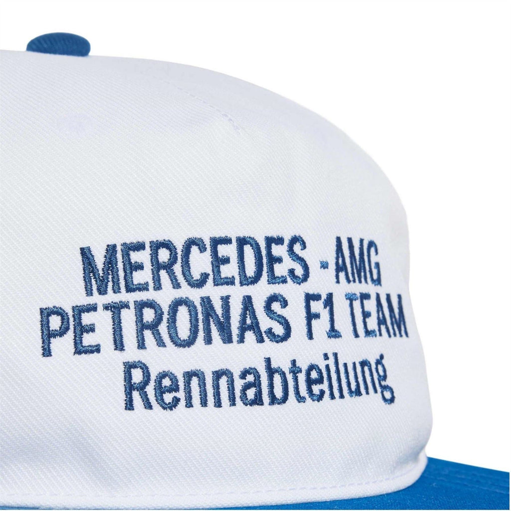 White snapback cap with blue text 'MERCEDES-AMG PETRONAS F1 TEAM' embroidery