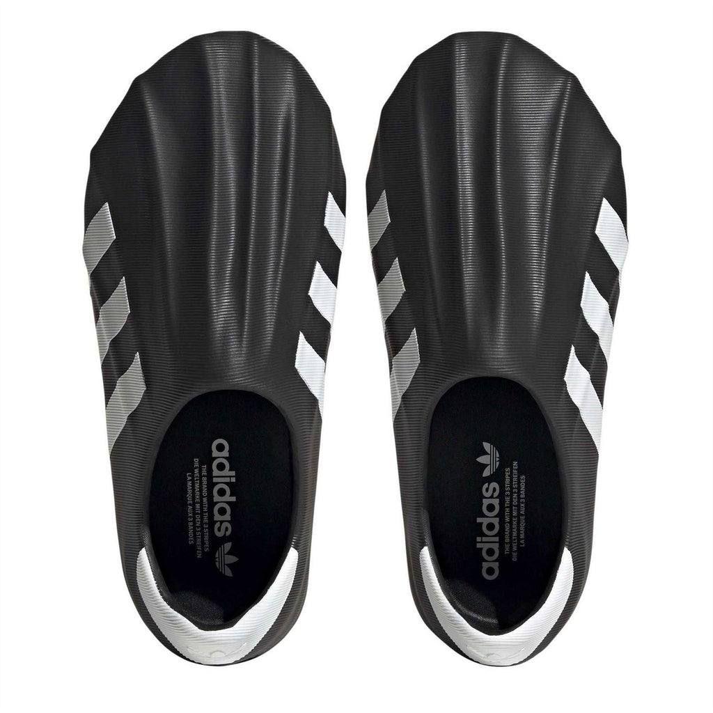 Black slip-on sneakers showing heel openings and white-striped upper panels