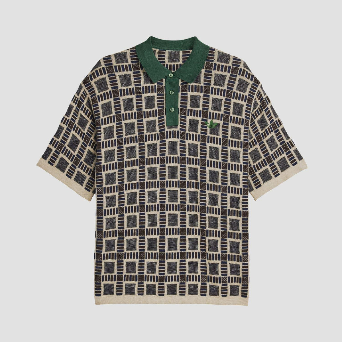 Front view of sand polo shirt; green collar and button placket with navy geometric grid.