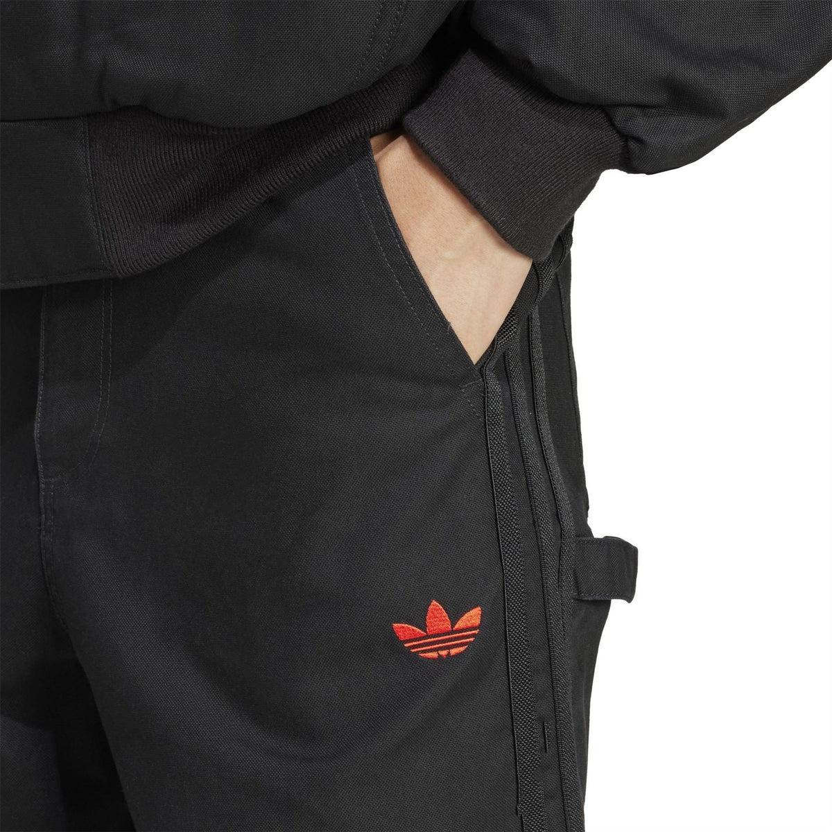 adidas Originals 100T black pants with red trefoil emblem and utility pocket detail
