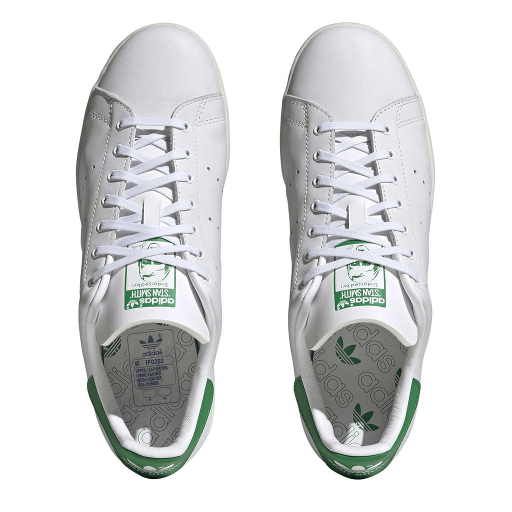 White sneakers with lace-up front and green insole branding detail