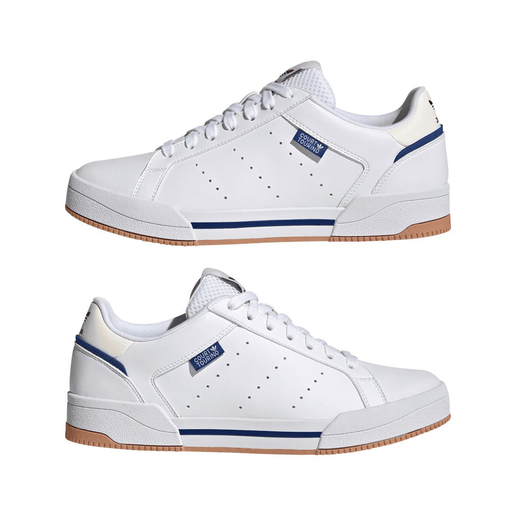 Pair of white adidas lace-up trainers with blue accents and gum-brown outsole