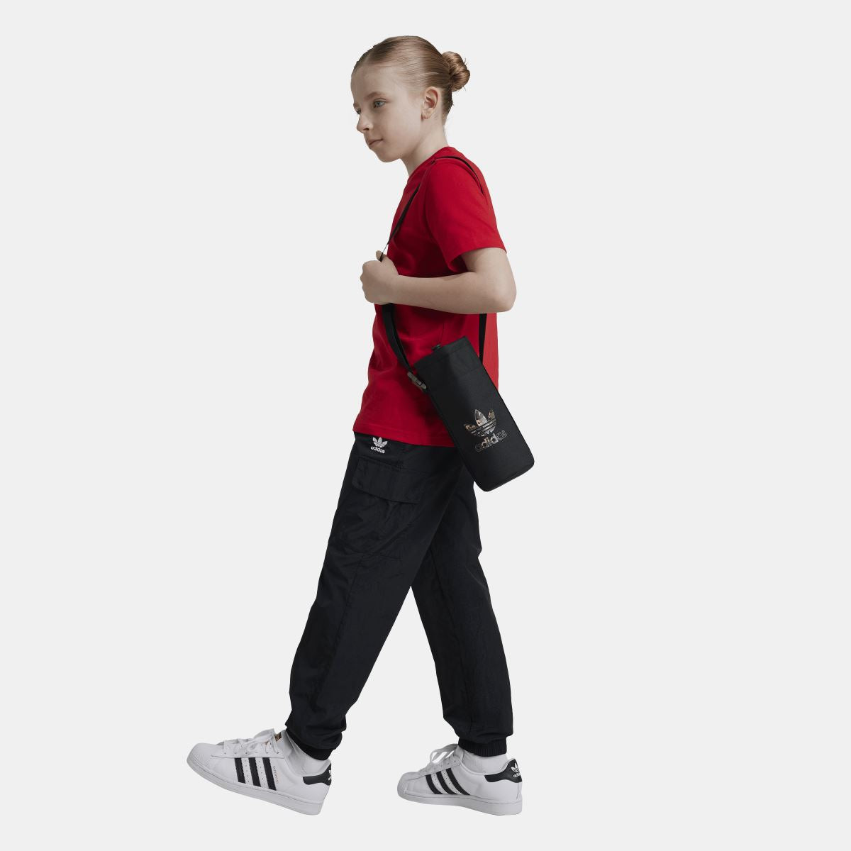 Junior black cargo track pants worn by a child, with elastic waist and cuffed hems