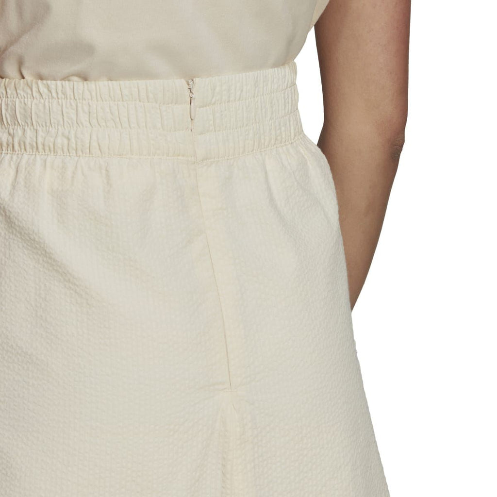 Adidas Originals Adicolor Classics poplin skirt with a high-waisted fit and vibrant color, worn with casual styling.