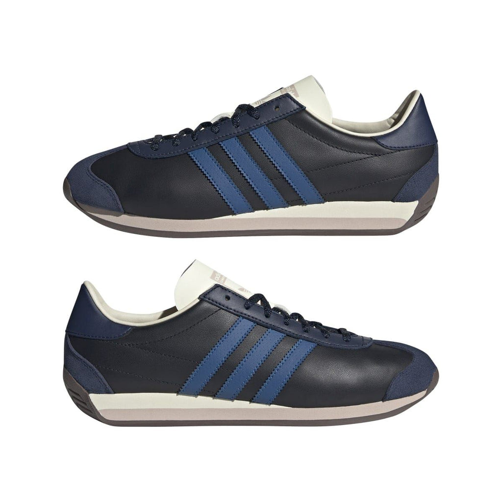 Pair of navy/black adidas trainers with blue stripes, cream details, and light rubber sole