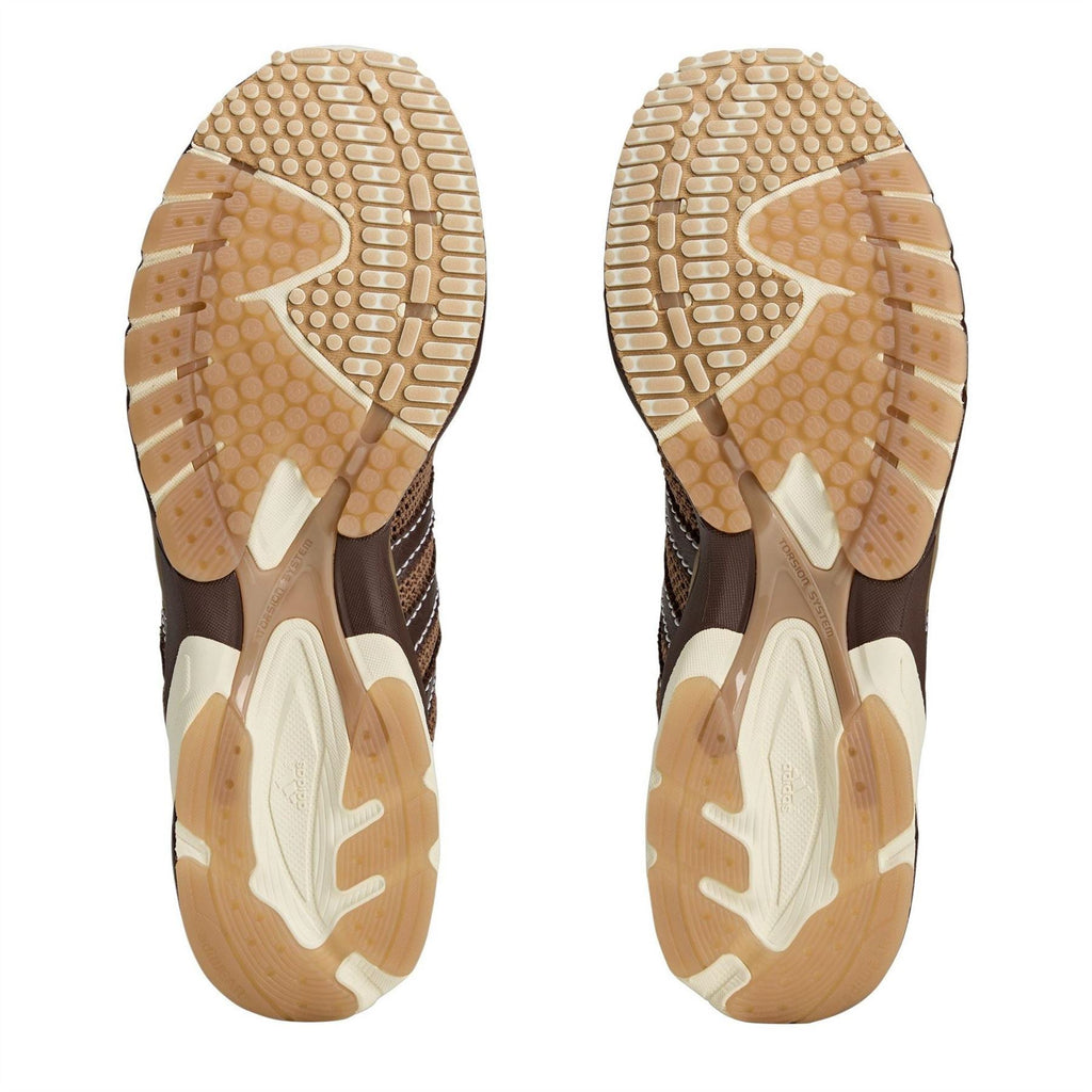 Underside view of brown and cream running shoe outsoles with tread pattern.