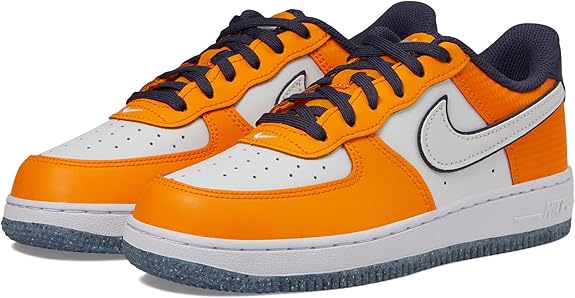 Kids' low-top sneakers in orange, white, and navy with Nike swoosh on both shoes