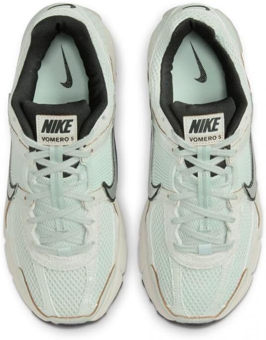 Pair of women's Nike Zoom Vomero 5 sneakers with light silver uppers and Nike heel tab.