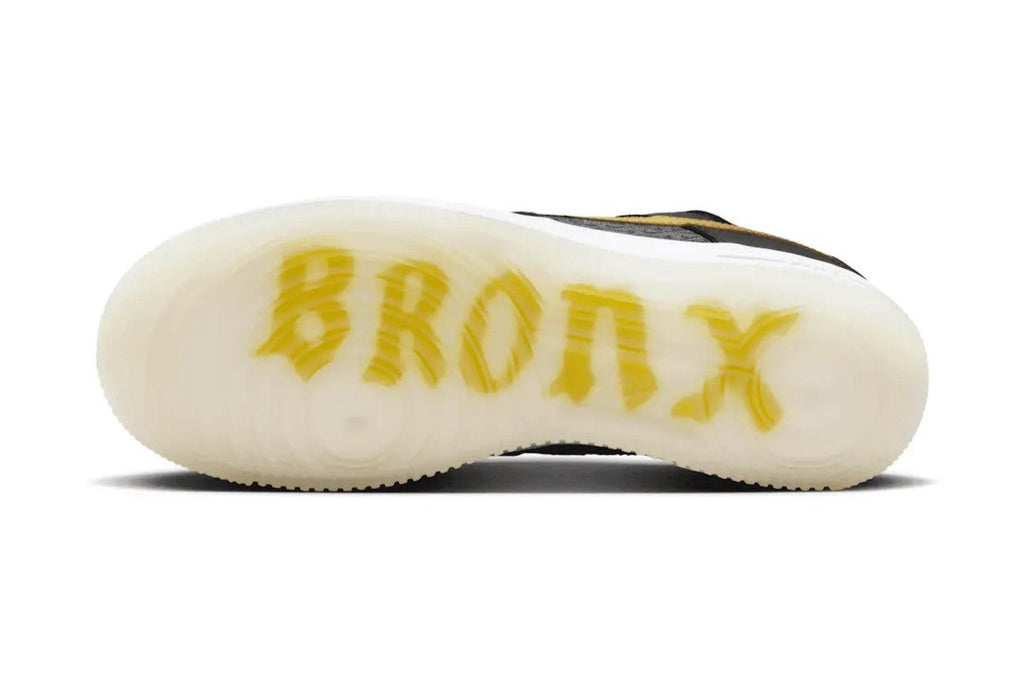 Cream rubber outsole with yellow lettering on black kids low-top sneakers