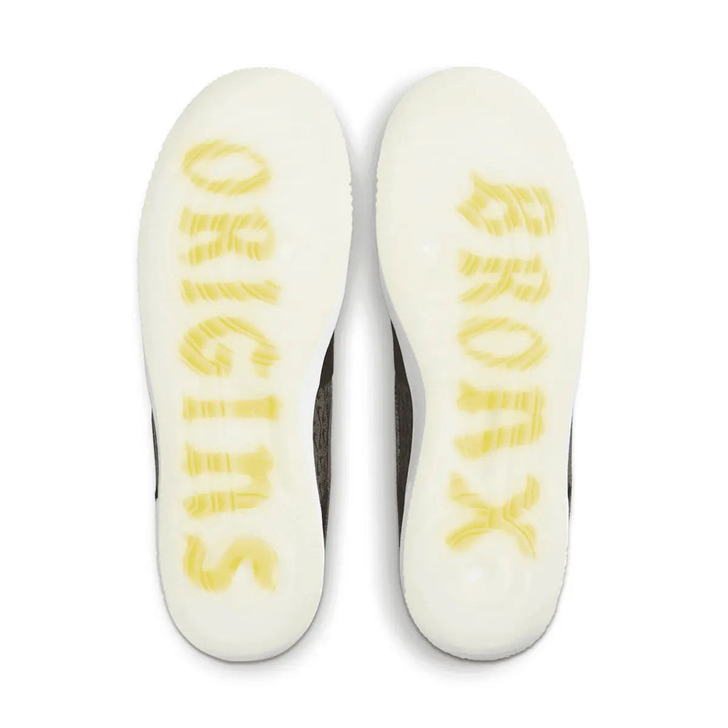 White shoe soles with yellow printed text on black kids low-top sneakers