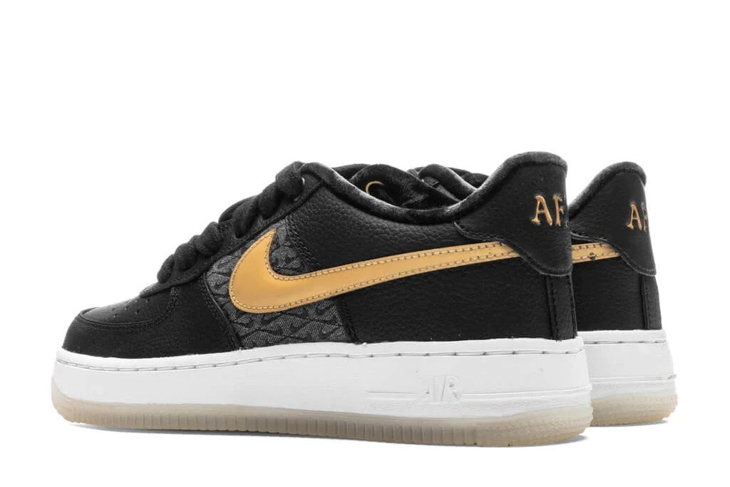 Kids black low-top sneakers with gold swoosh and AF1 logo on heel tab, white sole