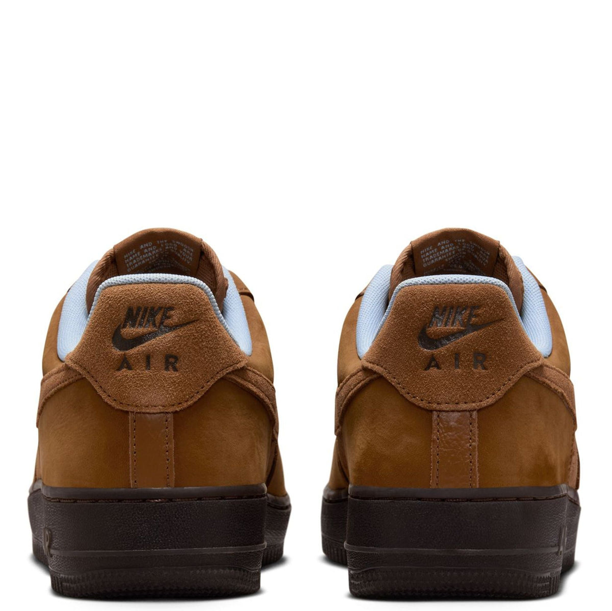 Back view of Nike Air Force 1 sneakers in tan suede, with Nike Air heel logo.