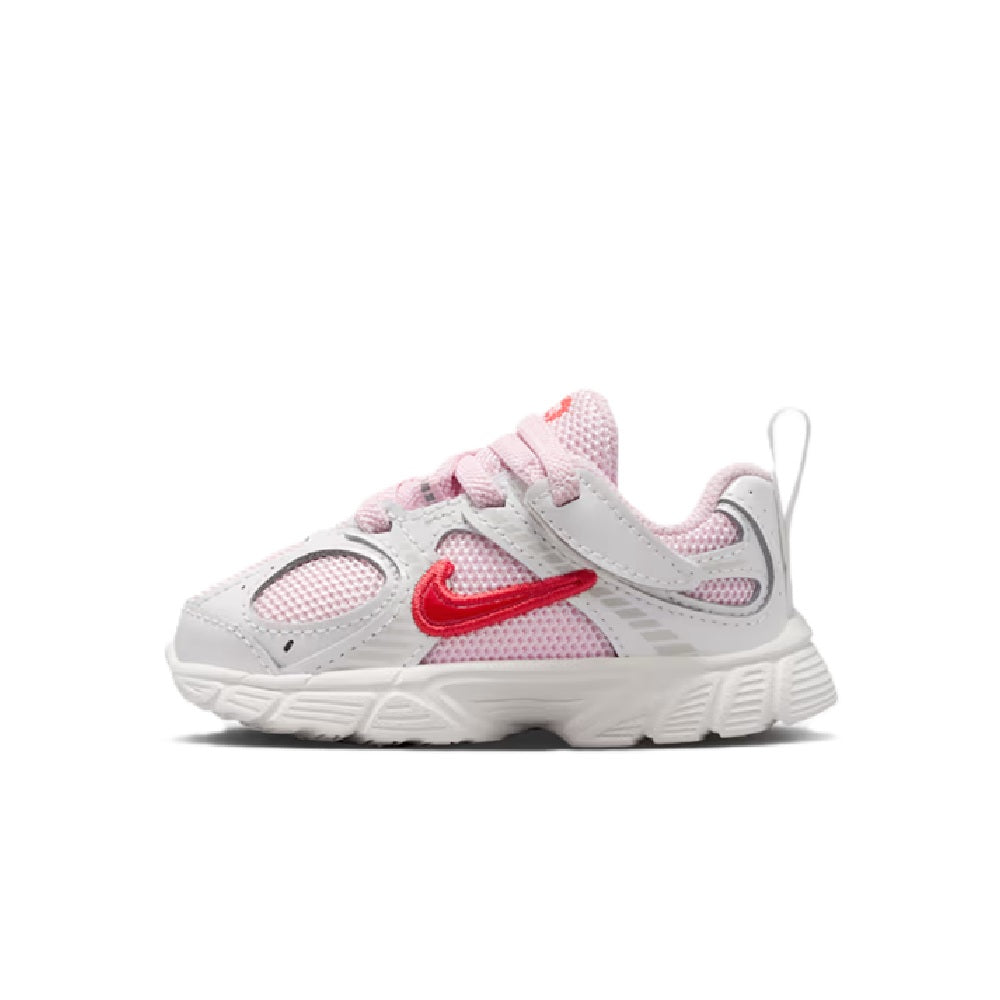 Kids' Nike running shoes, side view, white with pink panels and red Swoosh accents
