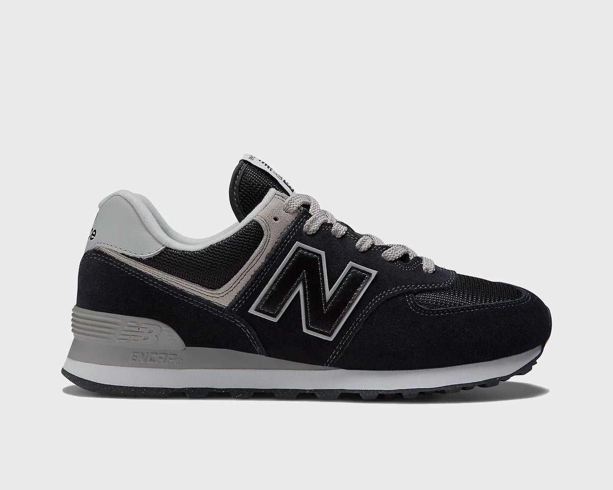Black low-top sneakers with gray accents, white N logo, and rubber outsole