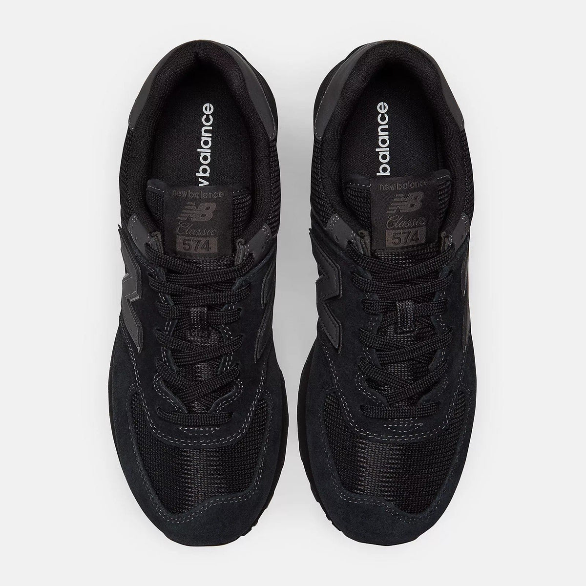 Black sneakers pair front view showing padded tongue and lace details inside