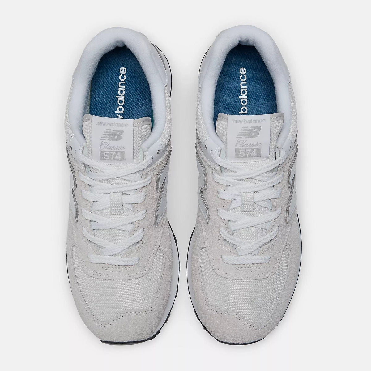 White sneakers pair, lace-up style with blue New Balance tongue and logo text